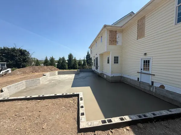 Large finished concrete patio behind a home by First Class Concrete